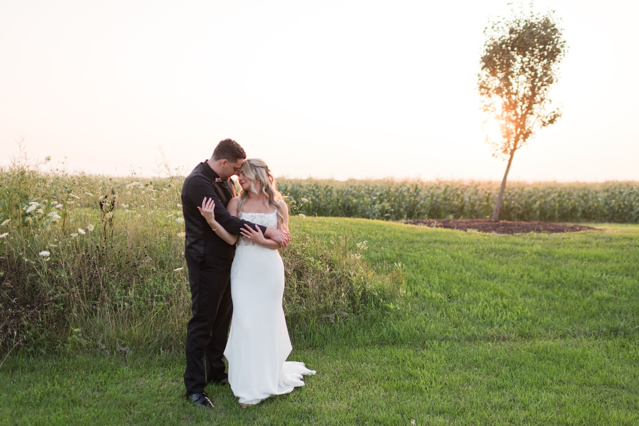 Bride and Groom posing for a portrait at their summer wedding at The Barn & Vineyard